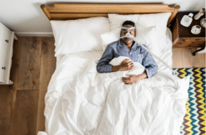 Man sleeping with an anti snoring mask