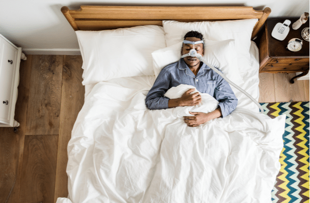Man sleeping with an anti snoring mask