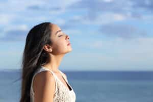 Profile of a beautiful arab woman breathing fresh air in the beach