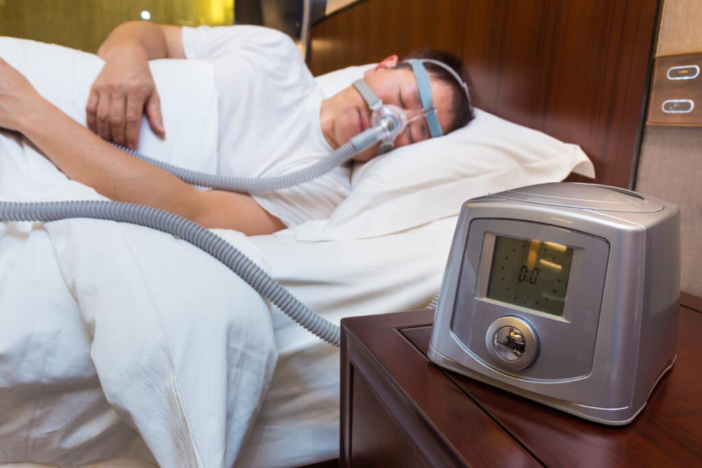 Man with sleep apnea using CPAP machine