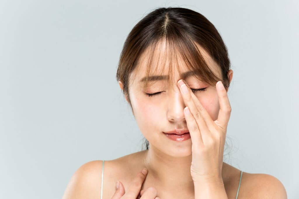 Woman touching her nose in discomfort from a nasal obstruction